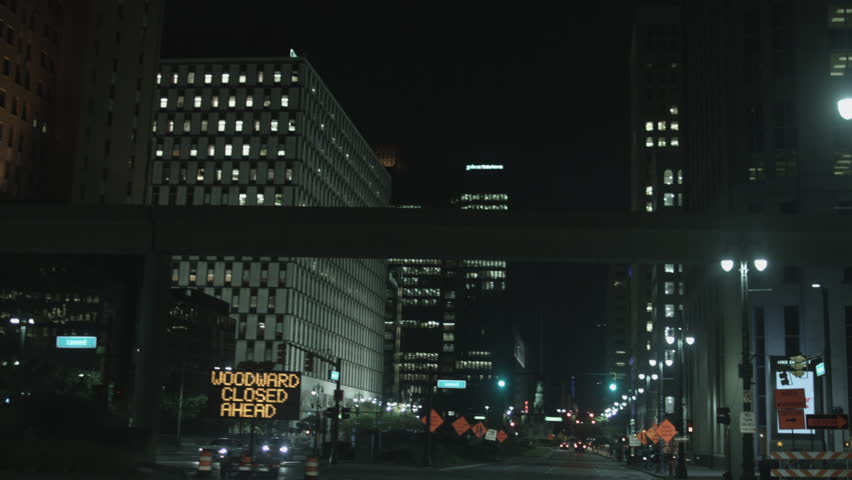 DETROIT, MI - CIRCA 2014: Driving plate: front view. Jefferson Ave turn on to Woodward in down town at night past high-rise commercial property.  Mid West USA, overcast.  24mm lens, stabilized