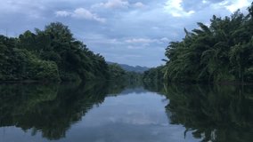 Beautiful landscape of Kwai Yai River early In the Morning surrounded by jungle and mountains in Kanchanaburi Province, Thailand.4K footage clip