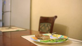 A man eats a steak at home in a family setting. close-up