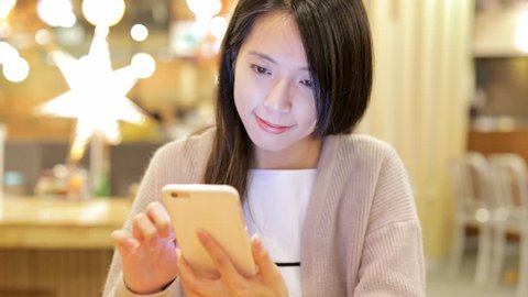 Woman using mobile phone inside restaurant
