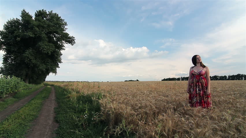 Wheat field,  young couple holding hands and walking through wheat field.
