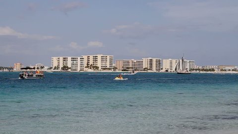 Vacationers boating in Destin Pass with condominiums on the far beach of Destin, Florida, USA.