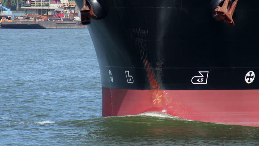 The bulbous bow on the front of a large industrial cargo ship.