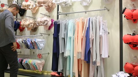 Man chooses panties for a girl in a women's underwear store