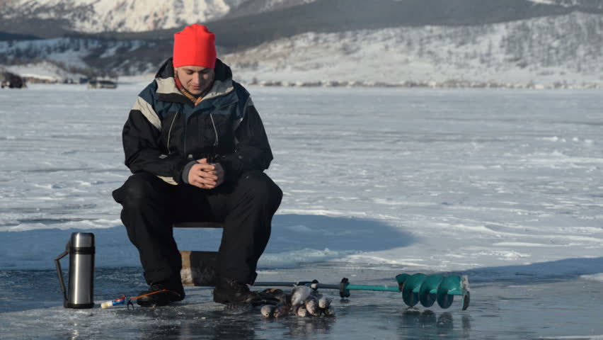 Fisherman is a man in winter fishing.