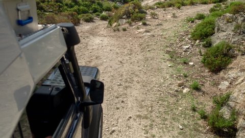 4k shot from a camera attached to the side of an off road campervan driving on rough tracks in sardinia, italy