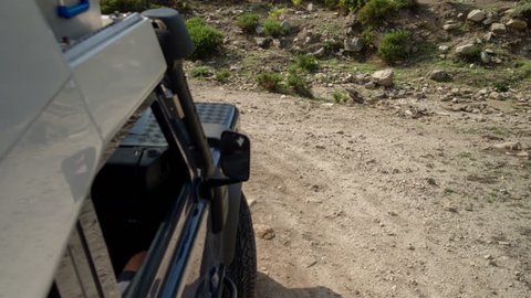 4k shot from a camera attached to the side of an off road campervan driving on rough tracks in sardinia, italy. the vehicle loses traction and slips backwards in this clip