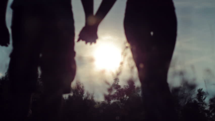 hands of lovers while sunset