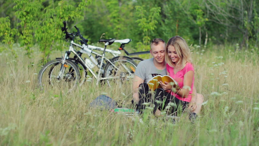 Attractive couple holding books  during studying in the park 