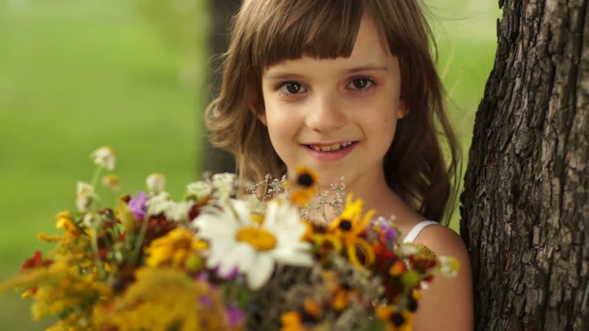 Girl gives viewers a bouquet of wildflowers
