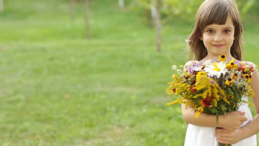 Portrait of a girl with a bouquet of flowers. The child goes out of frame
