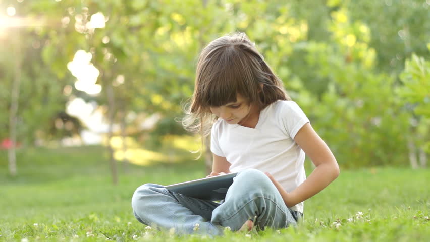 Girl with a Tablet PC outdoors and looking at camera
