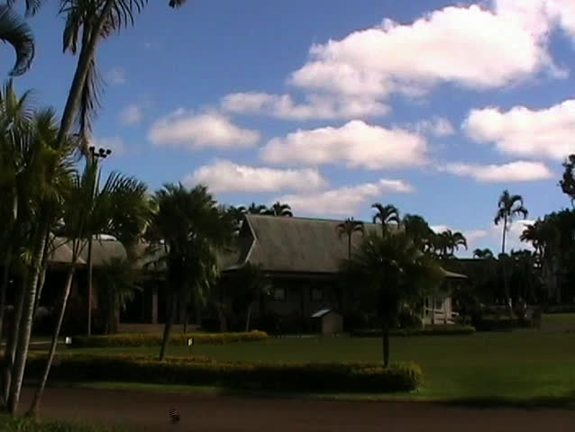 A view of the pro shop at a golf course in Hawaii (golf cart drives by) -
