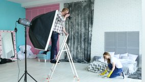 Photo studio backstage . Man photographer explain poses to  woman model like housewife. 
