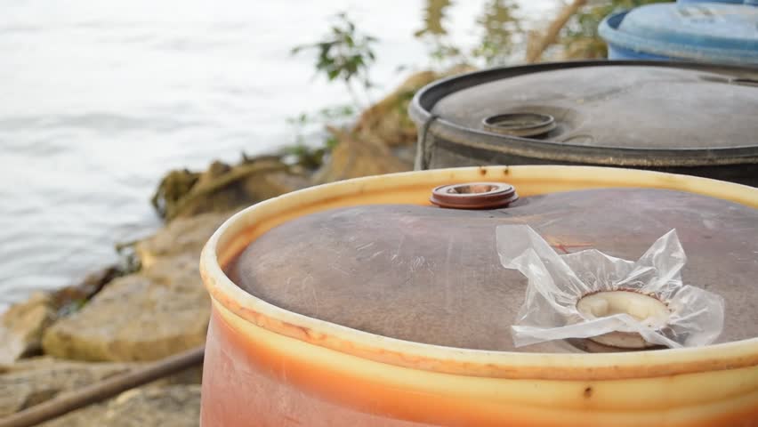 barrels by a river. view from a jetty towards the river. 