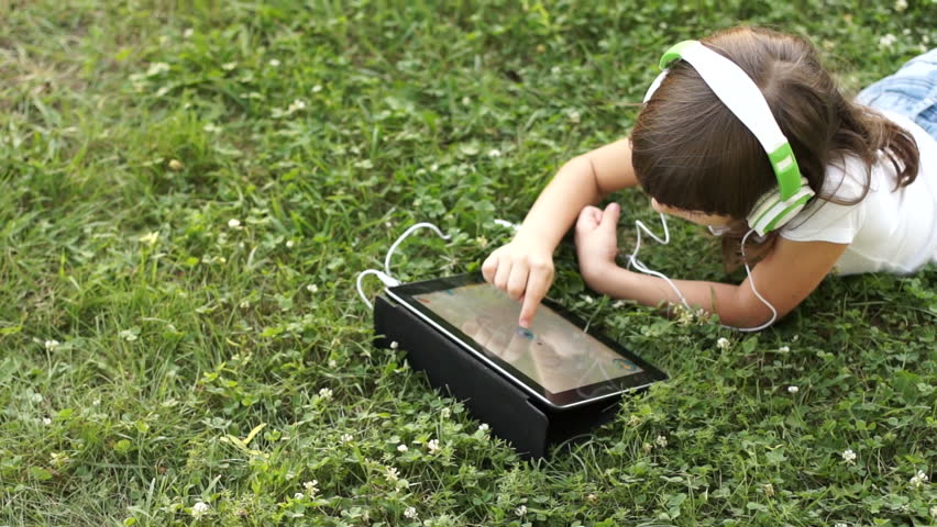Drawing a girl with a finger in the tablet pc outdoors
