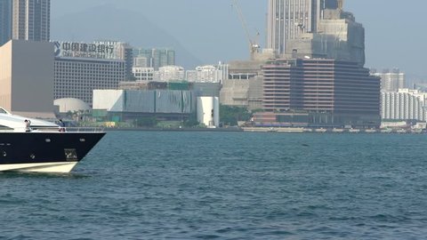 Slow motion of wild brown eagle flying near to ferry In Hong Kong With Cityscape Background, View of the Kowloon Peninsula. Cruise ship runs on the Victoria Harbour.-Dan