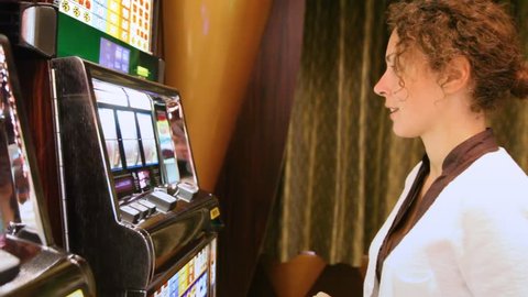 woman presses buttons on slot machine and wins