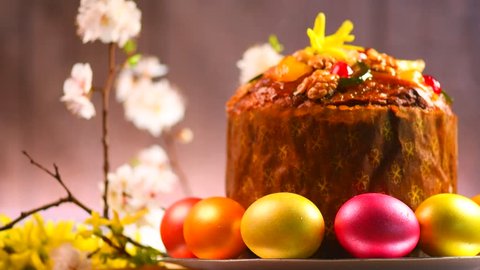 Easter Cake and colorful painted Eggs. Traditional Easter spring holiday food on wooden table background. Rotation. With copy space for your text. 4K UHD video 3840X2160