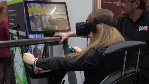 Hannover, Germany - March, 2017: Girl in virtual reality headset on training VR simulator on exhibition Cebit 2017 in Hannover Messe, Germany