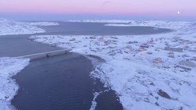 Beautiful village Teriberka at northern see coast. Winter cold. Arctic ocean waves storm. Dramatic cinematic 4K footage. Aerial drone UAV flight. High altitude bridge river