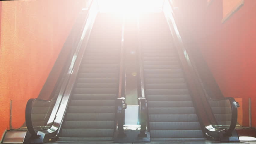 A dual escalator with ascending and descending moving stairs and a bright light