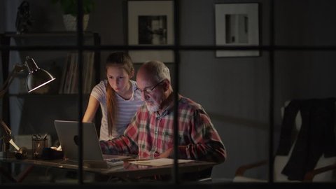 Medium zoom in shot of girl helping grandfather with laptop / Cedar Hills, Utah, United States