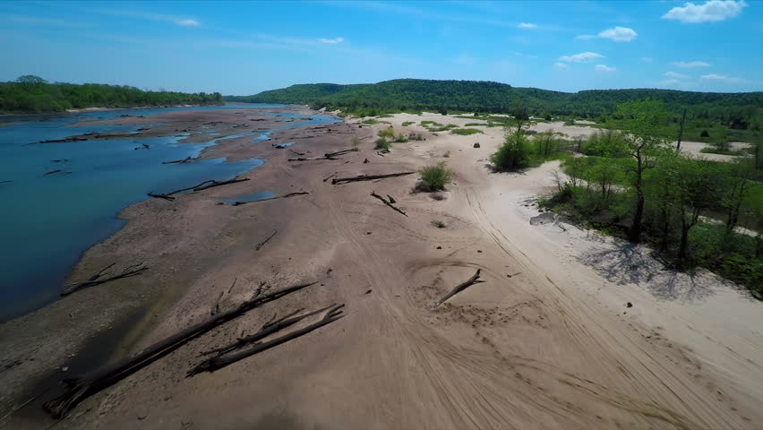 Aerial ATV off road on River clear water blue sky cinematic 4k drone sand sandy