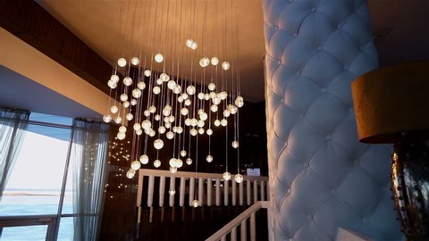 Hall of a hotel or restaurant, chandelier in the lobby, Chandelier hangs from the ceiling, creative, modern, interior, hotel or restaurant interior, Columns, white skin, motions, Bottom view