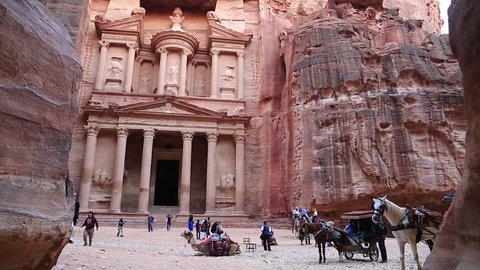 JORDAN, PETRA, DECEMBER 5, 2016: Horse and people near Al Khazneh or the Treasury at Petra, originally known to Nabataeans as Raqmu - historical and archaeological city in Hashemite Kingdom of Jordan