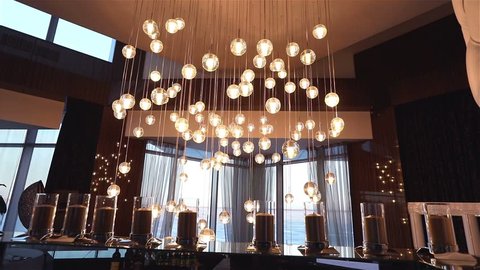 Hall of a hotel or restaurant, chandelier in the lobby, Chandelier hangs from the ceiling, creative, modern, interior, hotel or restaurant interior, Columns, white skin, motions, view, window