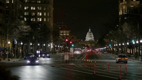 Wide panning shot of cars driving in city at night / Washington, District of Columbia, United States