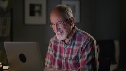 Close up panning shot of older man video chatting on laptop / Cedar Hills, Utah, United States