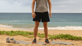 Jump Squats - Man doing Jump Squat exercise workout. Male fitness instructor training on beach.