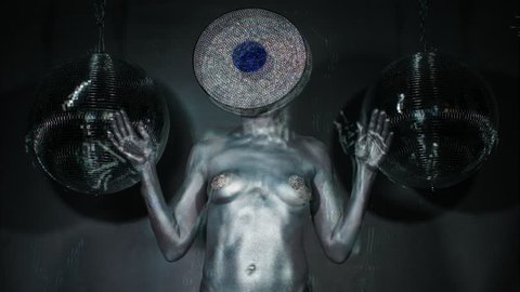 sexy disco woman painted in silver body paint with an amazing diamond crystal record vinyl as a head. this version has been passed through an analogue video effects unit to add glitch and distortion.