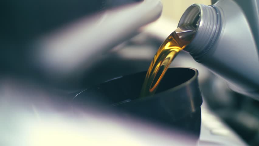 Pouring fresh new clean synthetic oil into car's engine, closeup. 4K UHD slow, motion. Royalty-Free Stock Footage #25975862