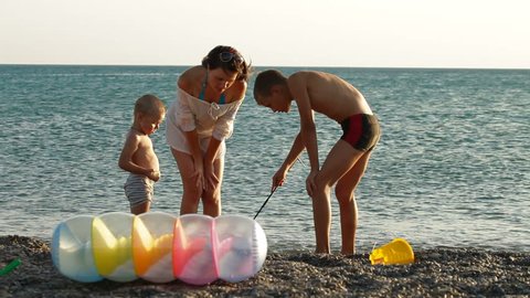 A mother with children spending time on summer beach