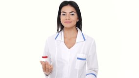 Young smiling woman nurse looking camera while throwing bottle with pills isolated