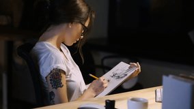 Woman designer wearing glasses drawing using pencil in office