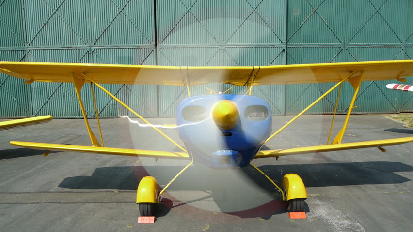 Propeller of a small biplane spinning round while at rest.