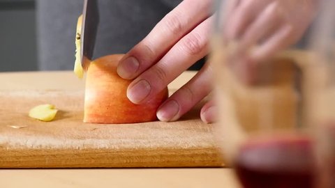 Cutting apple on slices. Preparing ingredients for baking apple pie. Chef slicing healthy apple at wooden plank in kitchen. Slicing peeled apples.
