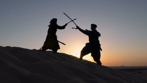 Sword fighting at sunset. Two men fights swords at sunset in the desert. Prince of Persia. Live action role-playing game. LARPing. LARP