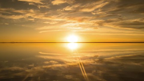 Time-lapse of the beautiful sunset and moving cloud, sun eventually sink under the horizon, all reflected on the water in Salar de Uyuni, Bolivia, South America.