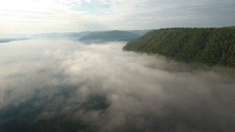 Angara river Russia Siberia. Mountains pine forest. White clouds morning fog. Open space. The sky is reflected in the blue water. Summer spring morning sun shines. Aerial helicopter drift  