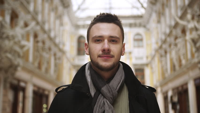 Portrait of handsome Caucasian young confident male standing in great passageway in Odessa in slowmotion