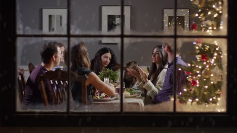 Medium zoom in shot of family talking at meal on Christmas behind window / Cedar Hills, Utah, United States
