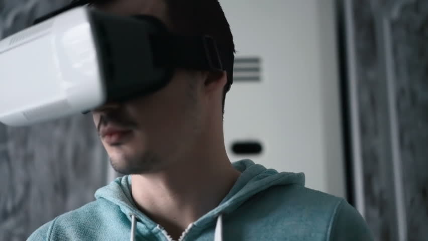 Man wearing virtual reality headset at living room.