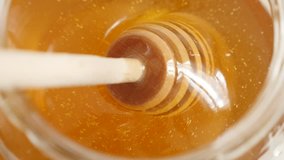 Healthy golden sweet food substance with wooden utensil slow-mo 1920X1080 HD footage - Close-up of spiral dipper used in honey jar slow motion 1080p FullHD video