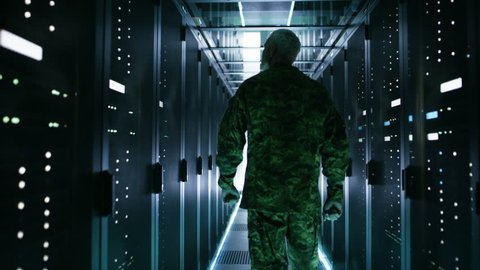 Soldier Walks into Data Center Through Sliding Doors and Walks along Rows of Working Rack Servers. Shot on RED EPIC-W 8K Helium Cinema Camera.