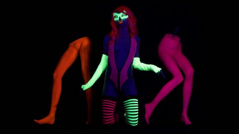 4k fantastic video of sexy cyber raver woman filmed in fluorescent clothing under UV black light. the woman has 2 extra mysterious legs.
